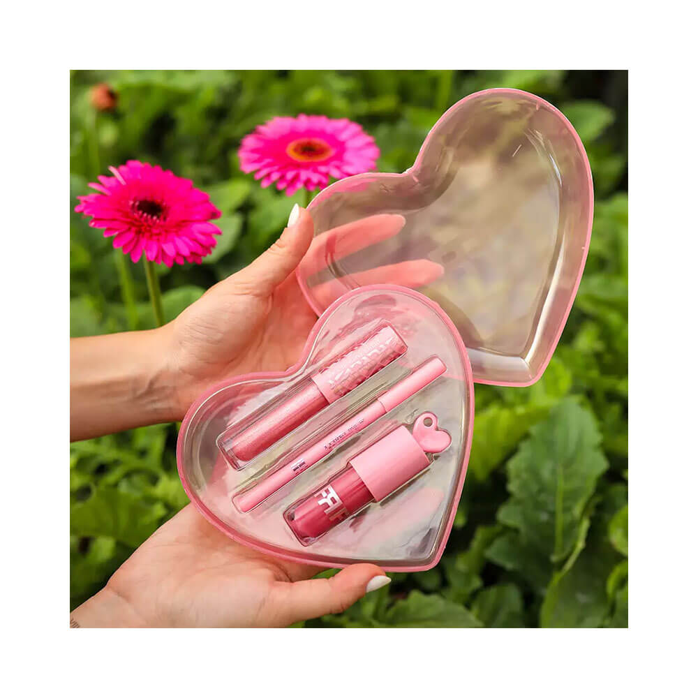 Produtos do kit abertos mostrando gloss, batom e lápis com folhagem