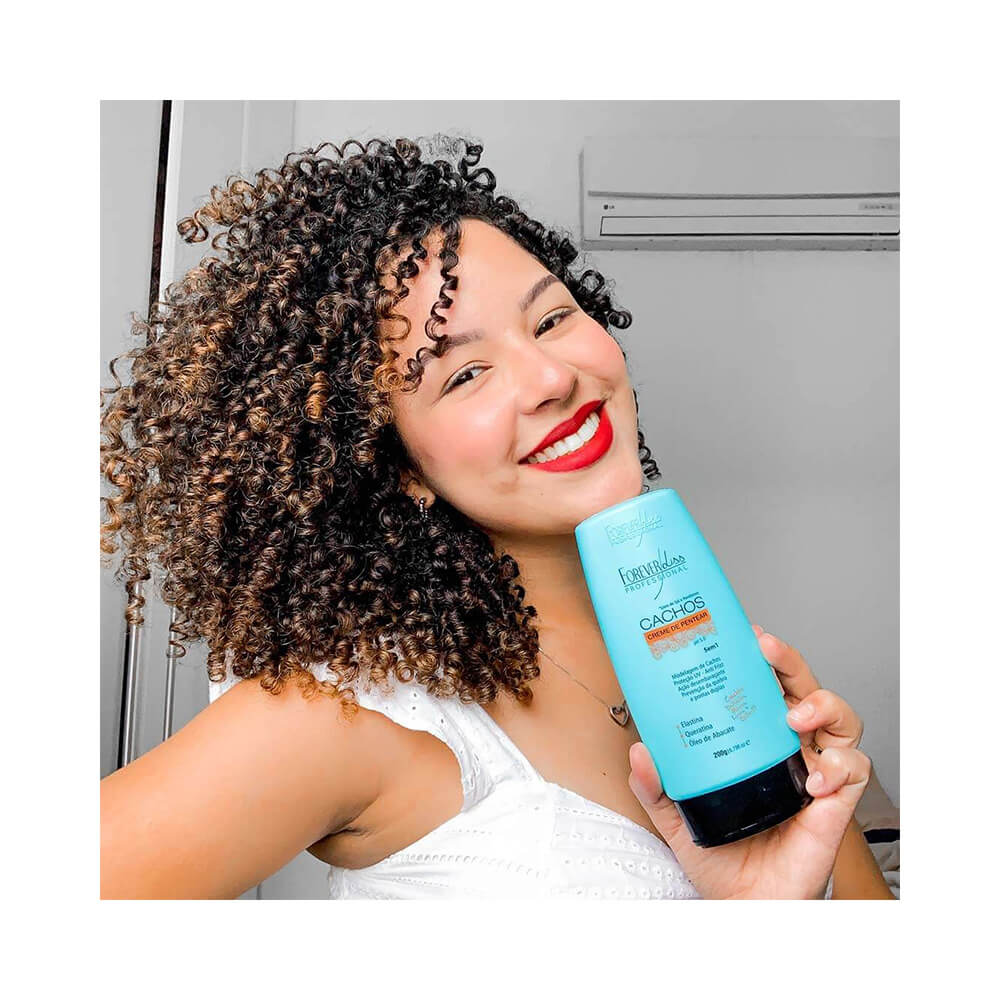 Mulher com cabelo cacheado segurando o creme de pentear Forever Liss