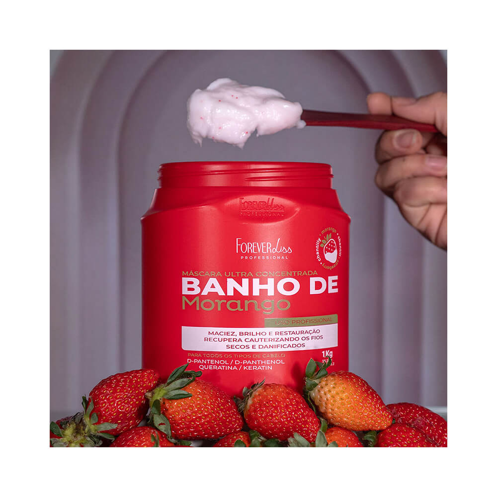 Pote aberto com creme rosa e morangos ao lado