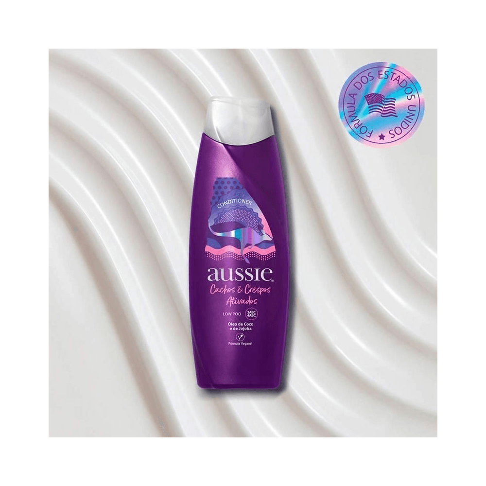 Frasco do condicionador Aussie 360ml sobre fundo perolado mostrando rótulo e selo