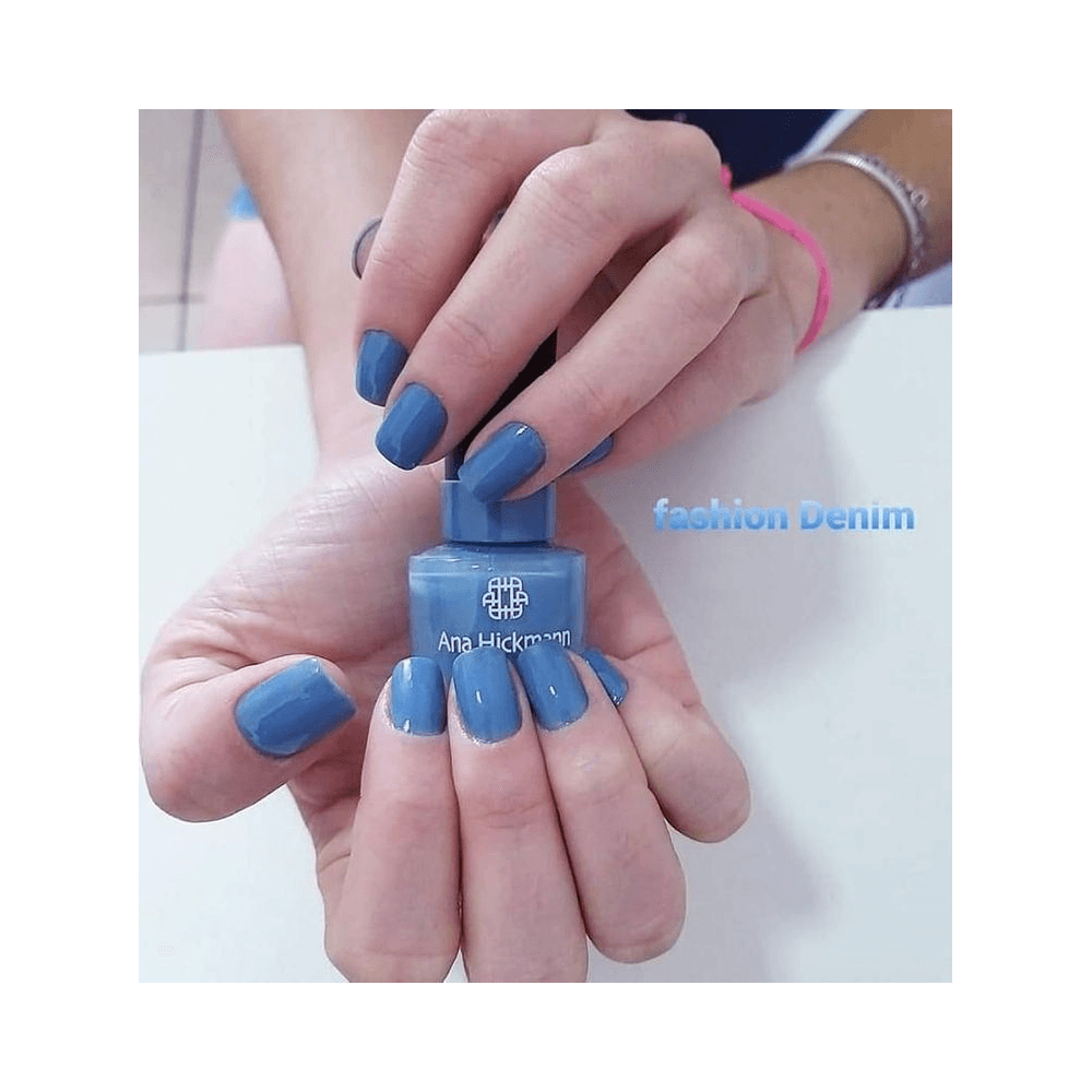 Close das mãos segurando o frasco de esmalte Ana Hickmann Fashion Denim com destaque no acabamento cremoso