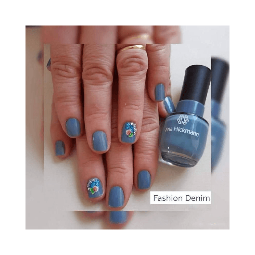 Mãos com unhas esmaltadas em tom Fashion Denim ao lado do frasco do esmalte