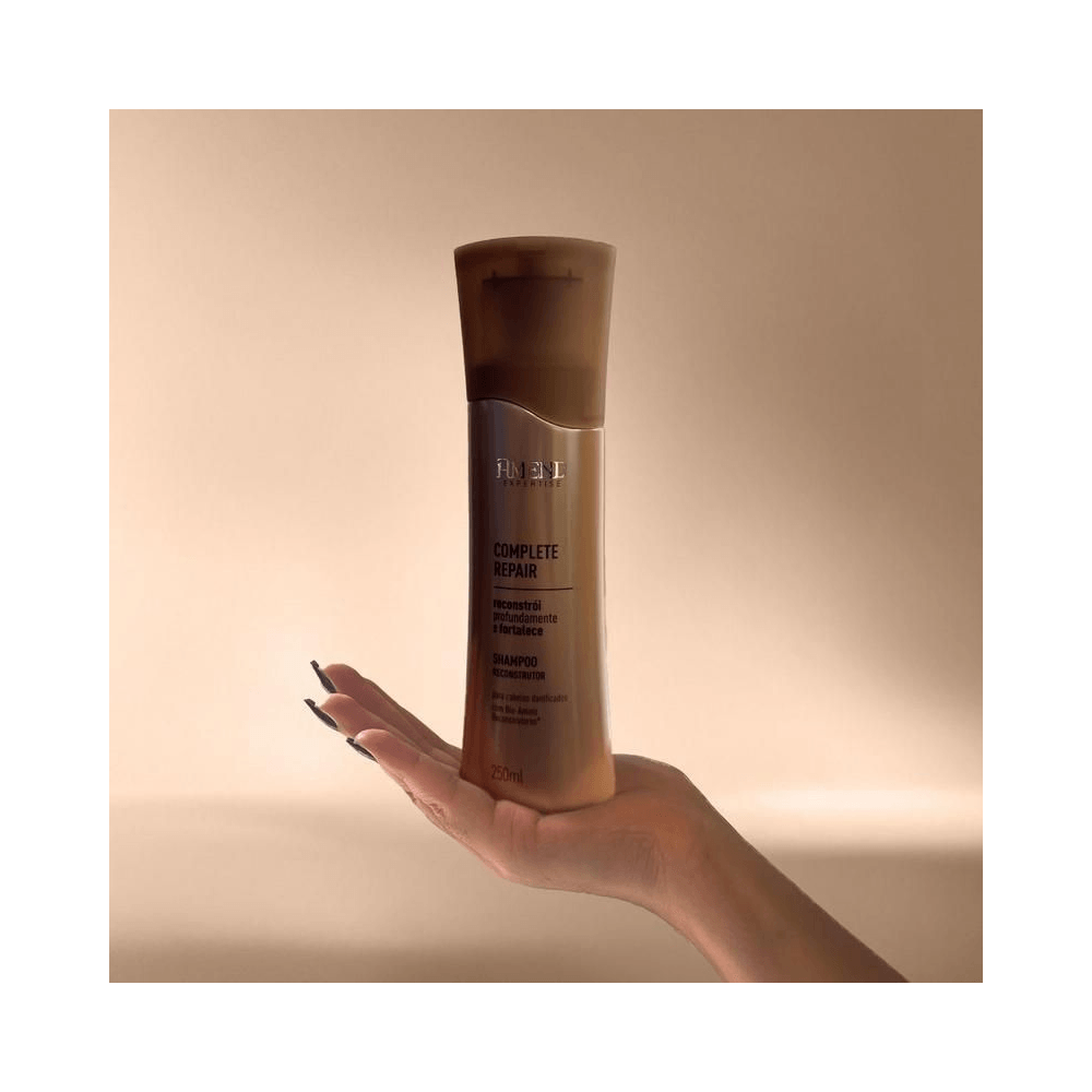 Shampoo Amend Complete Repair sendo segurado, destaque para embalagem bronze