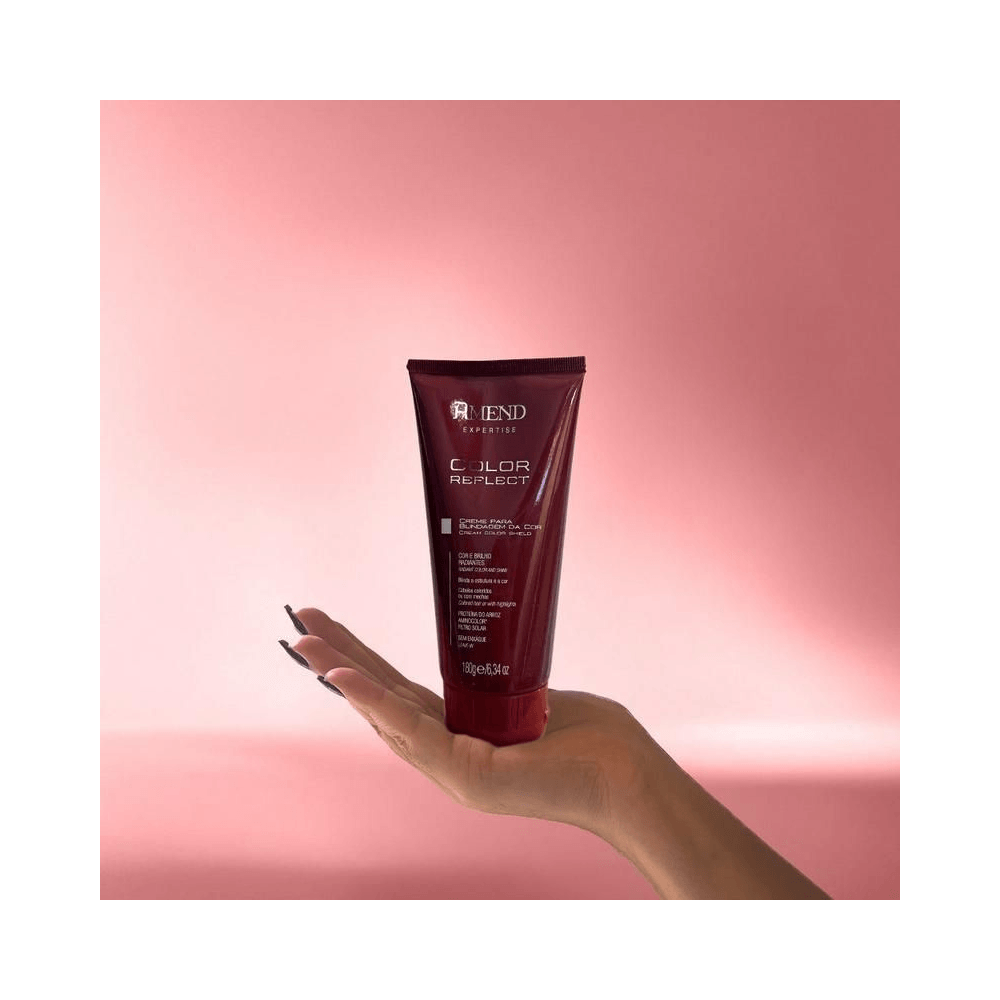 Tubo do Creme Amend Expertise Color Reflect 180g segurado por mão feminina sobre fundo rosa