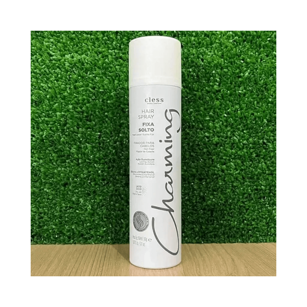 Frasco Hair Spray Charming sobre superfície de madeira com fundo verde