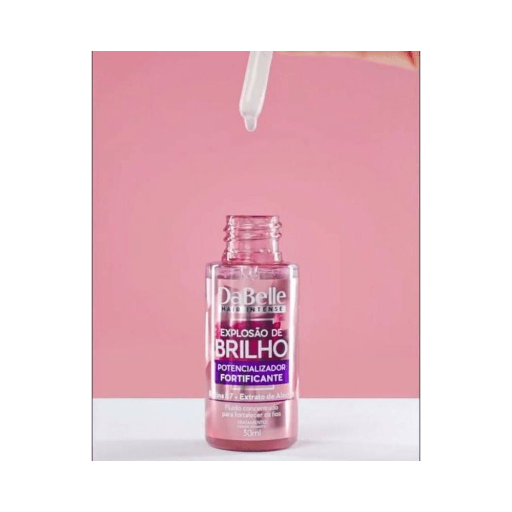 Frasco aberto do Fluido Capilar Dabelle 30ml em fundo rosa com conta-gotas pingando