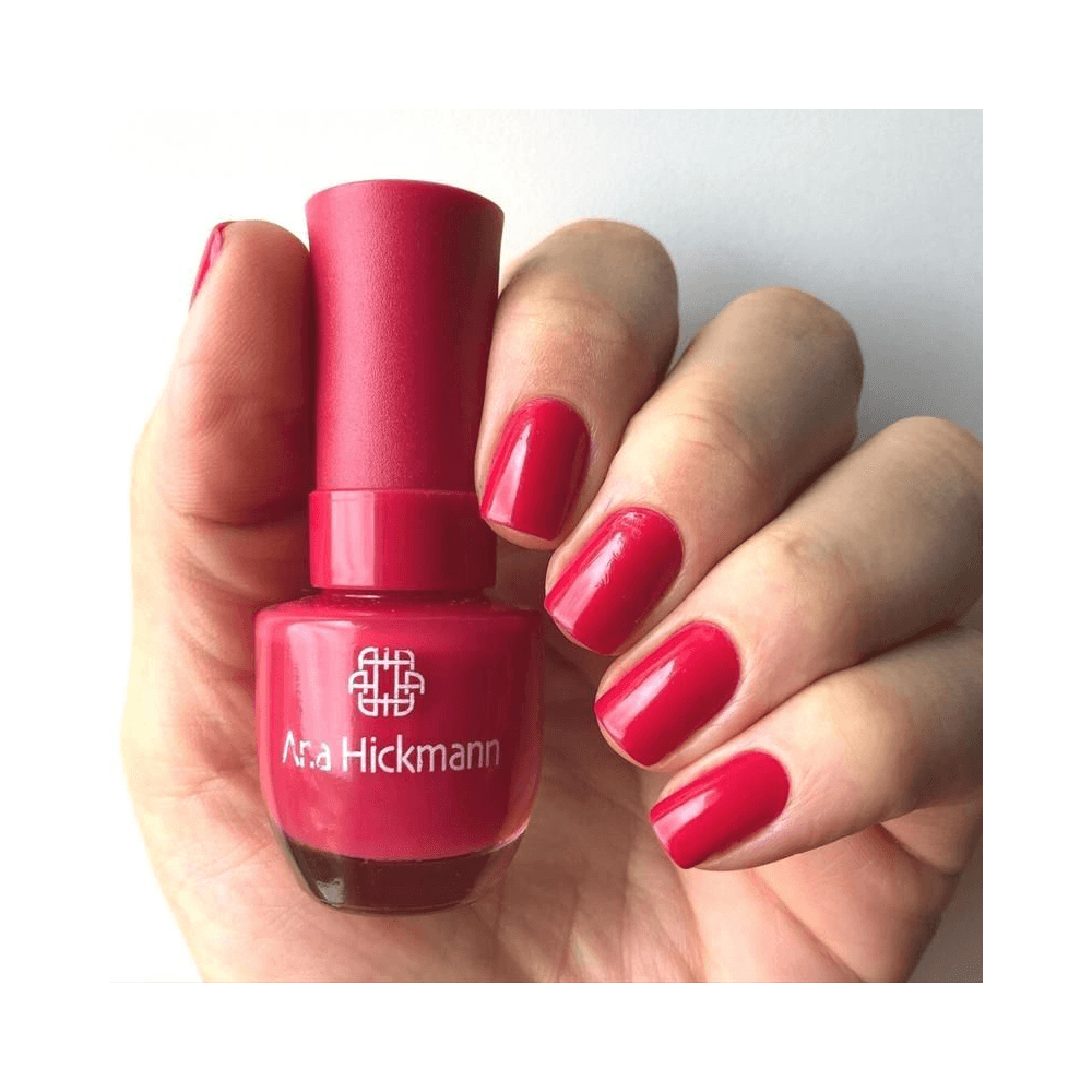 Mão segurando esmalte Ana Hickmann Pink Tropical com unhas pintadas