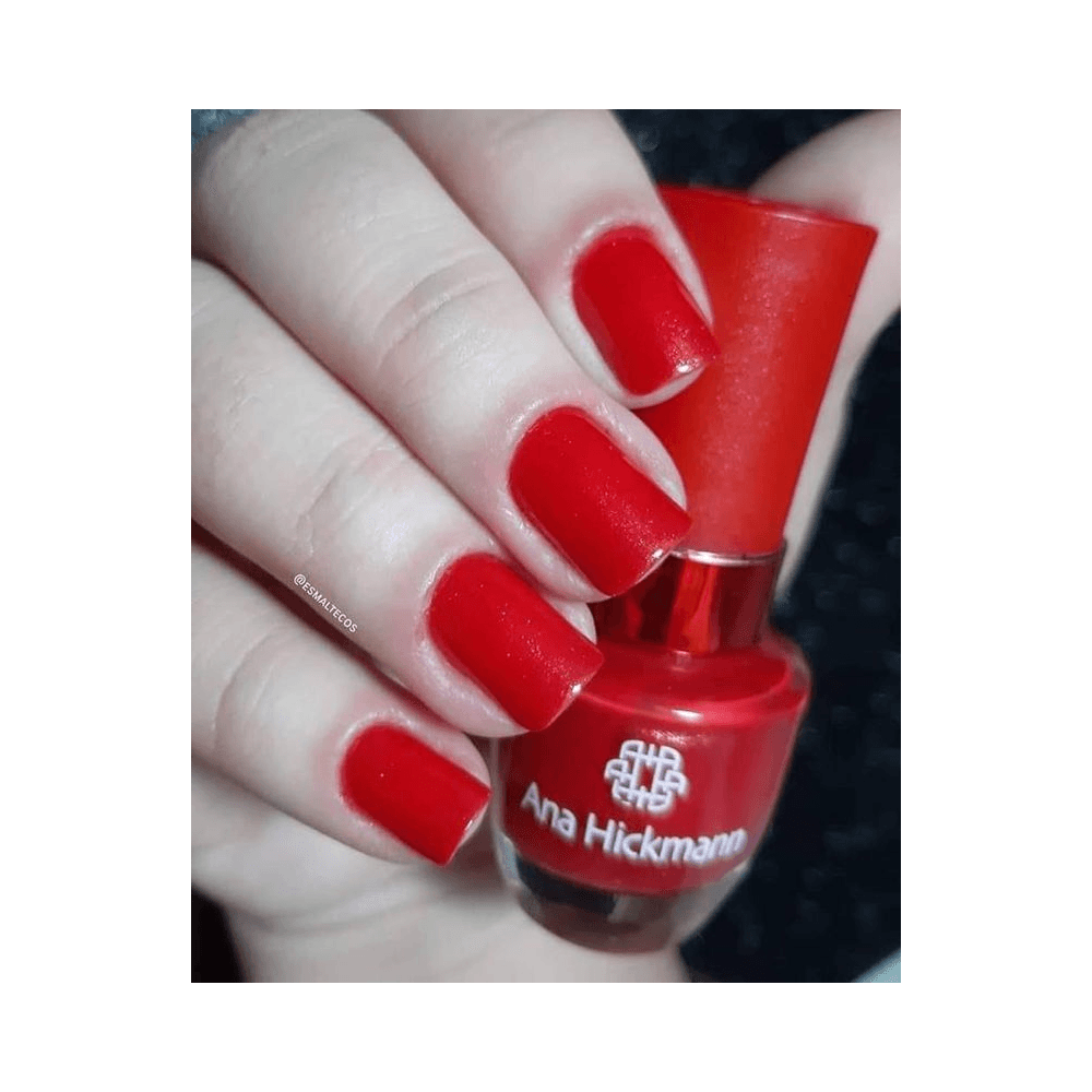 Mão com unhas pintadas no tom Night segurando o frasco
