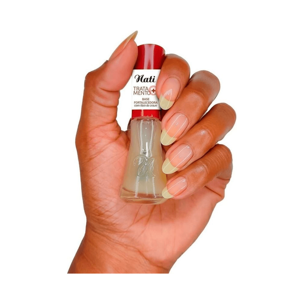 Mão segurando frasco da Base Nati, mostrando aplicação e resultado natural