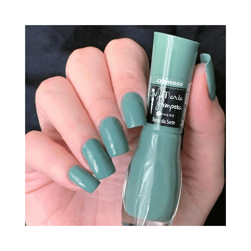Mão com unhas esmaltadas segurando o frasco do Esmalte Mohda Trevo da Sorte
